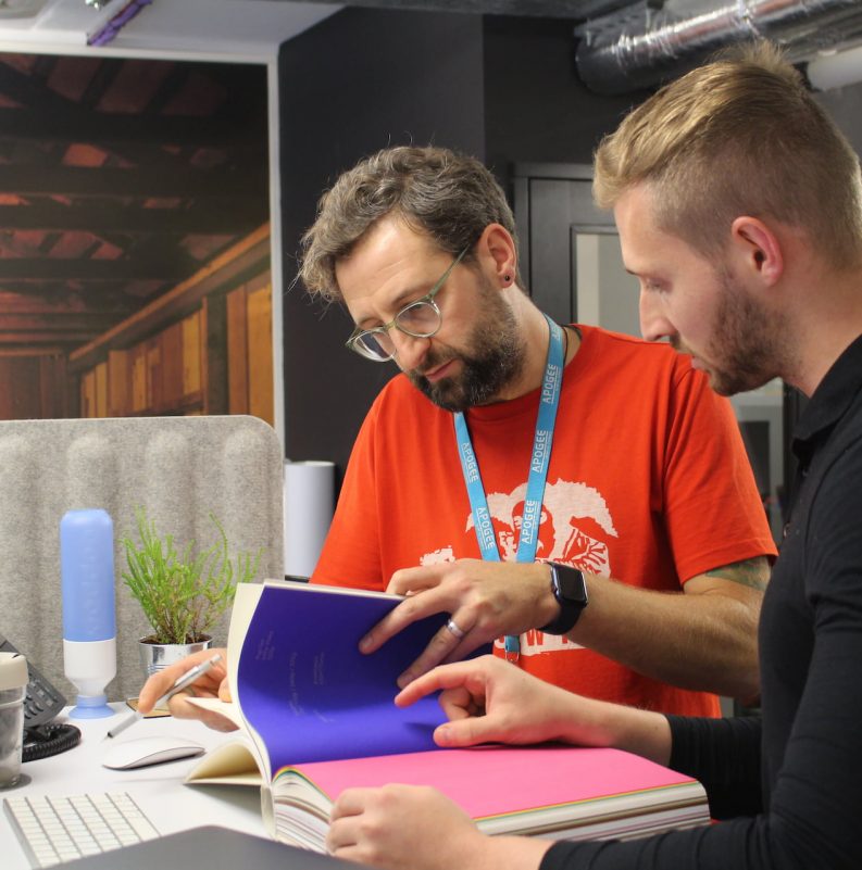 print designers looking at colour swatch book