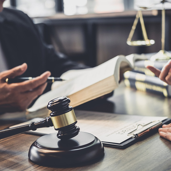 legal-600x600 hand holding legal book gavel scales of justice